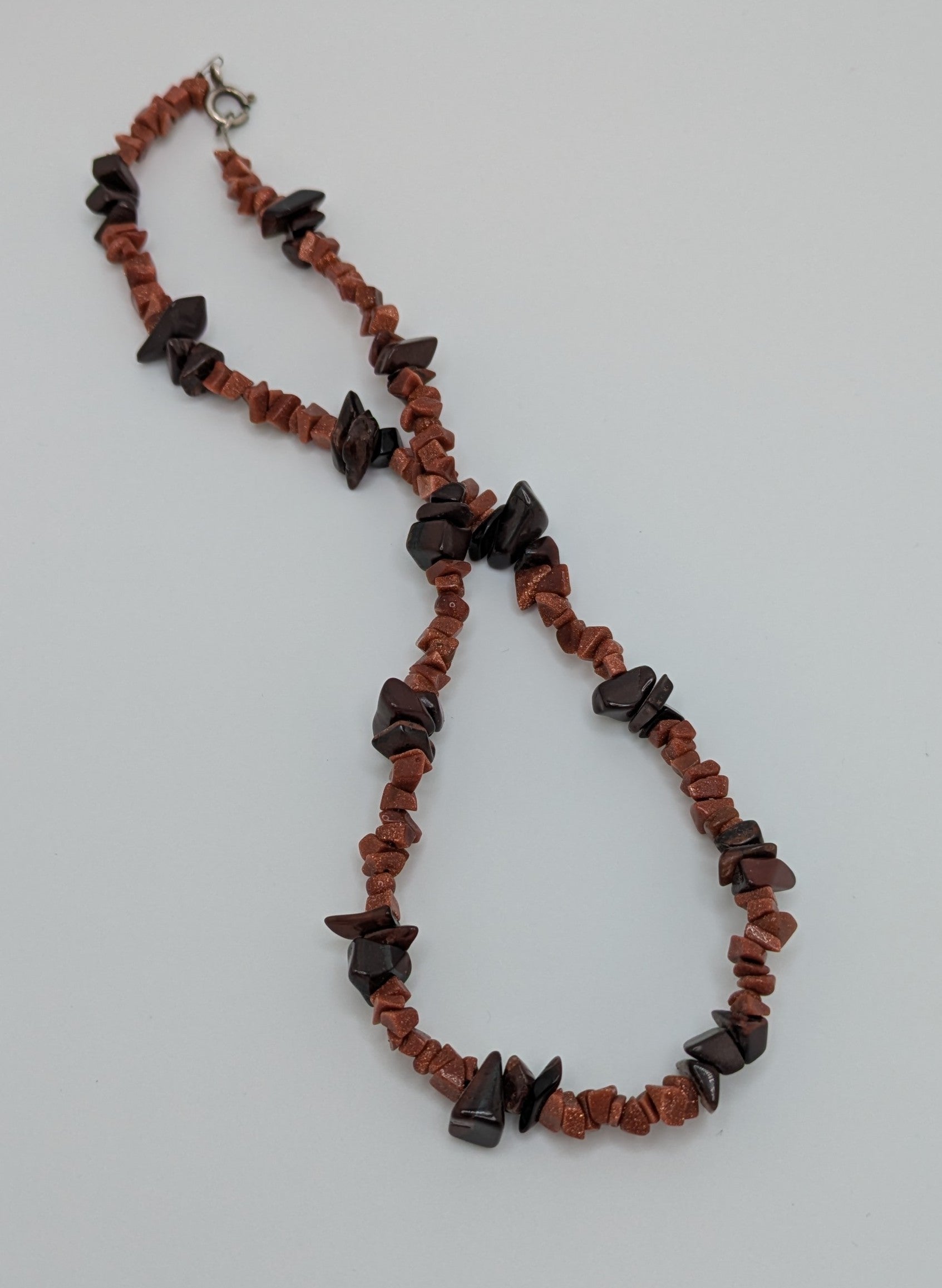 Necklace with red and black beads on a light gray background