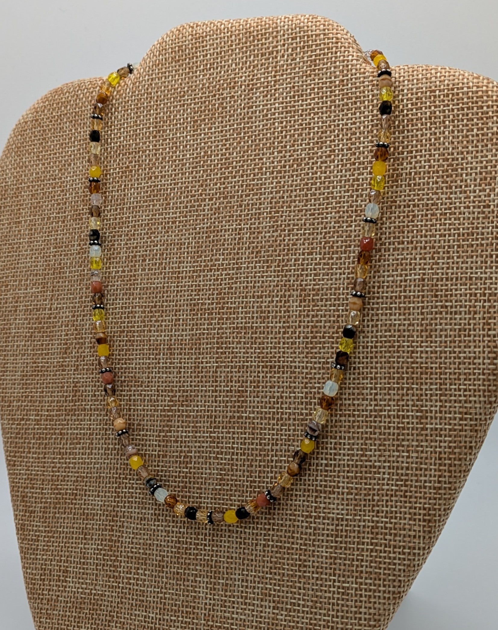 Beaded necklace on a brown fabric display
