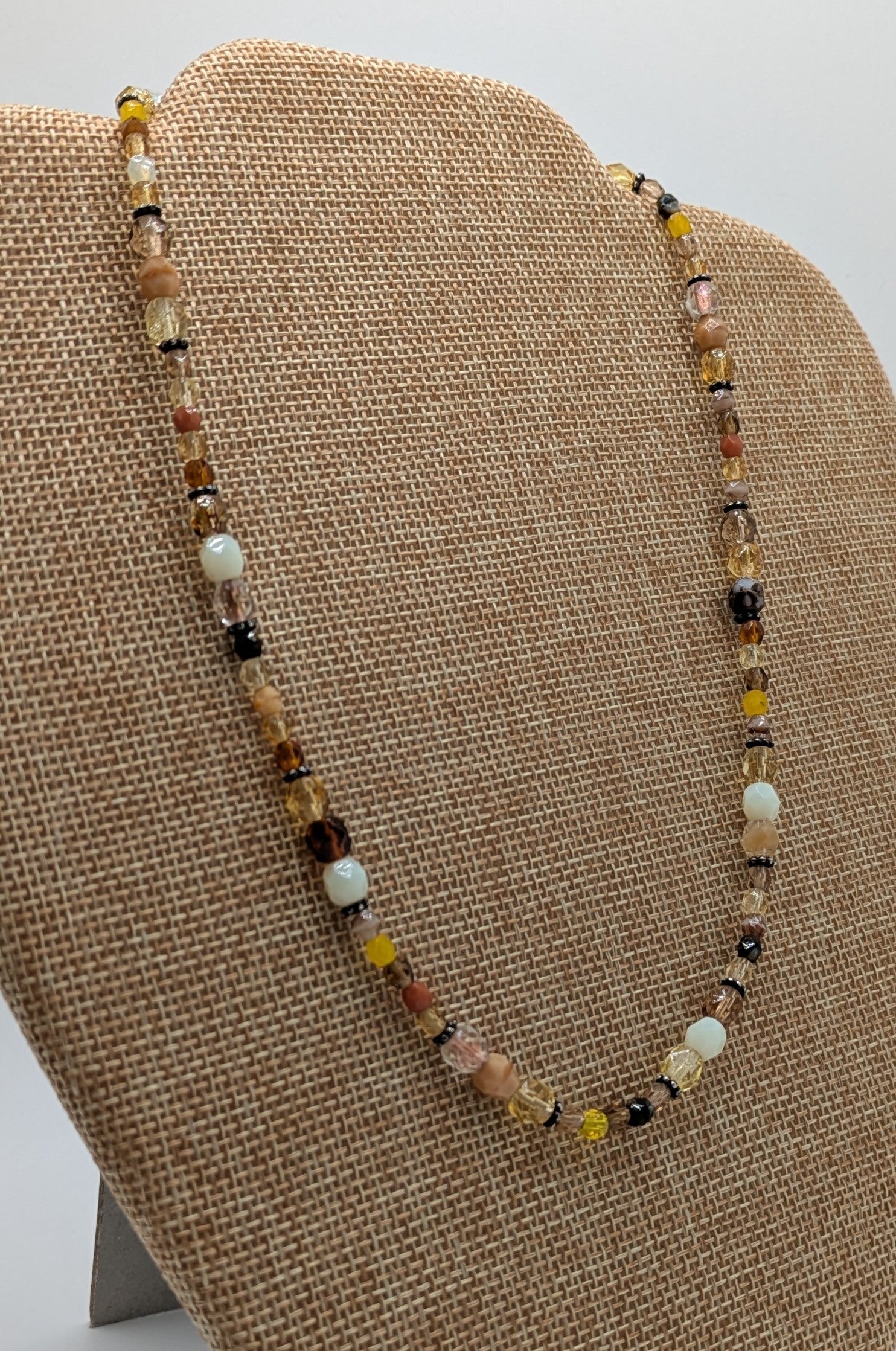Beaded necklace on a brown display stand