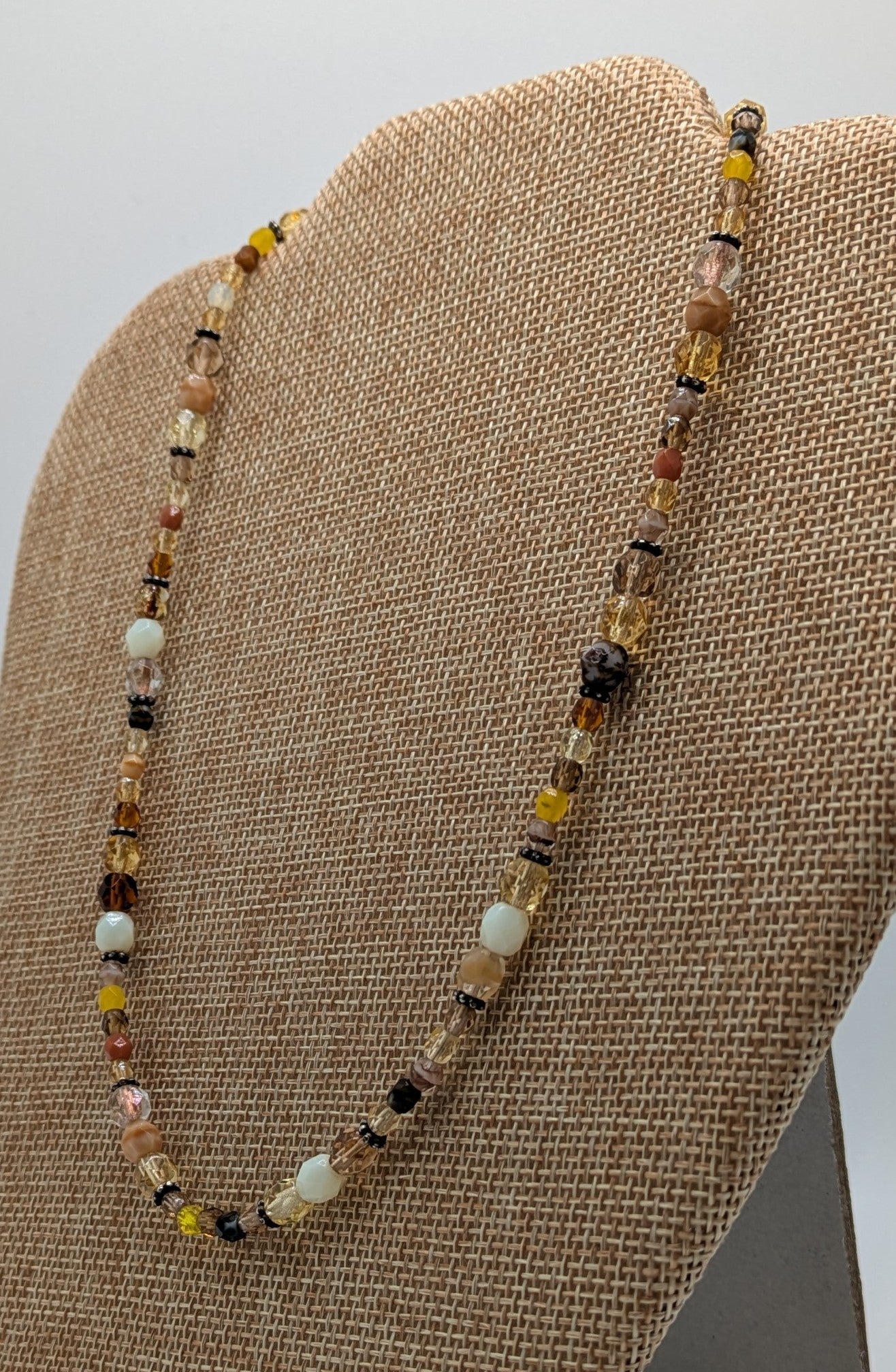 Beaded necklace on a brown fabric display