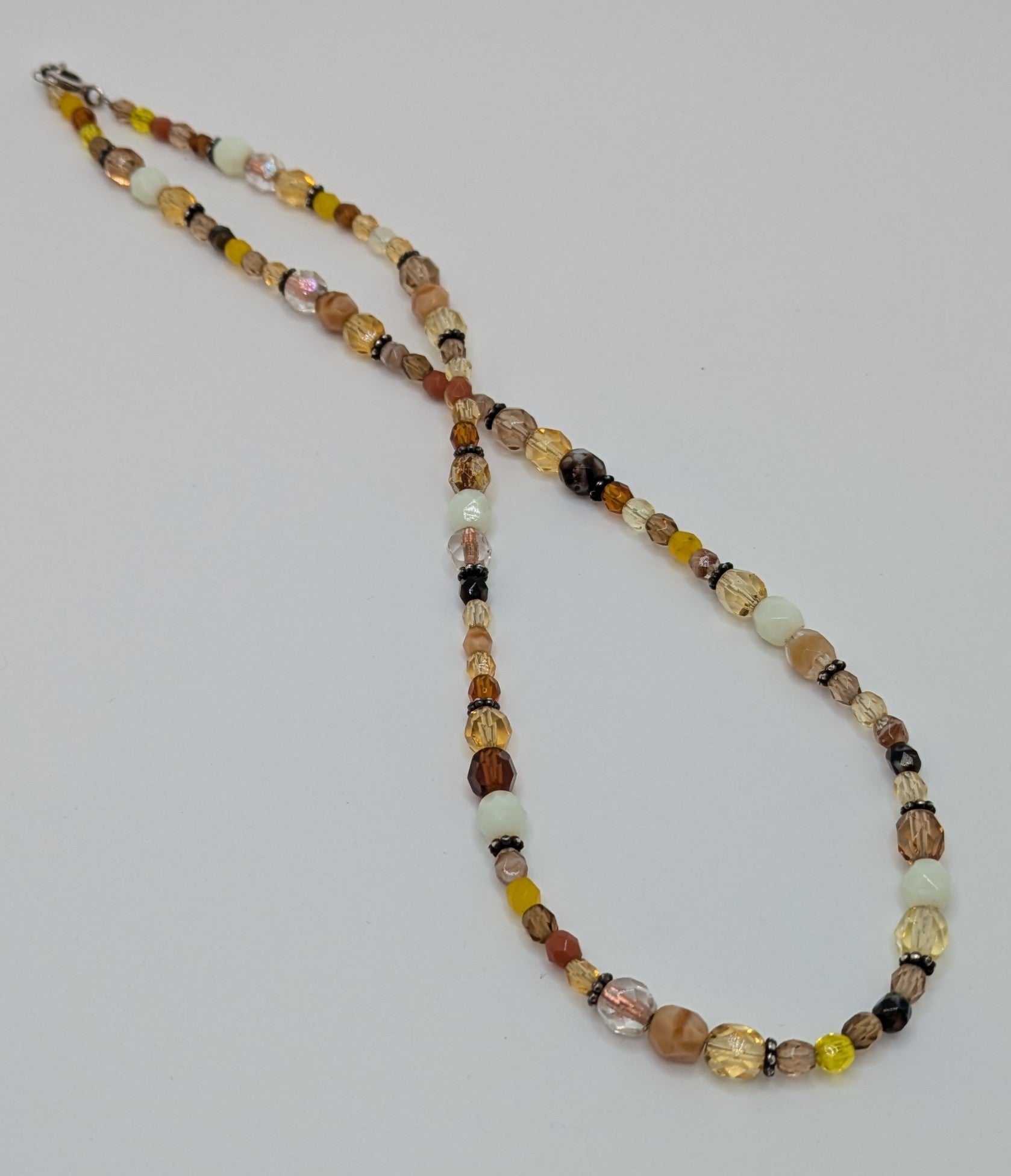 Beaded necklace with multicolored beads on a light gray background