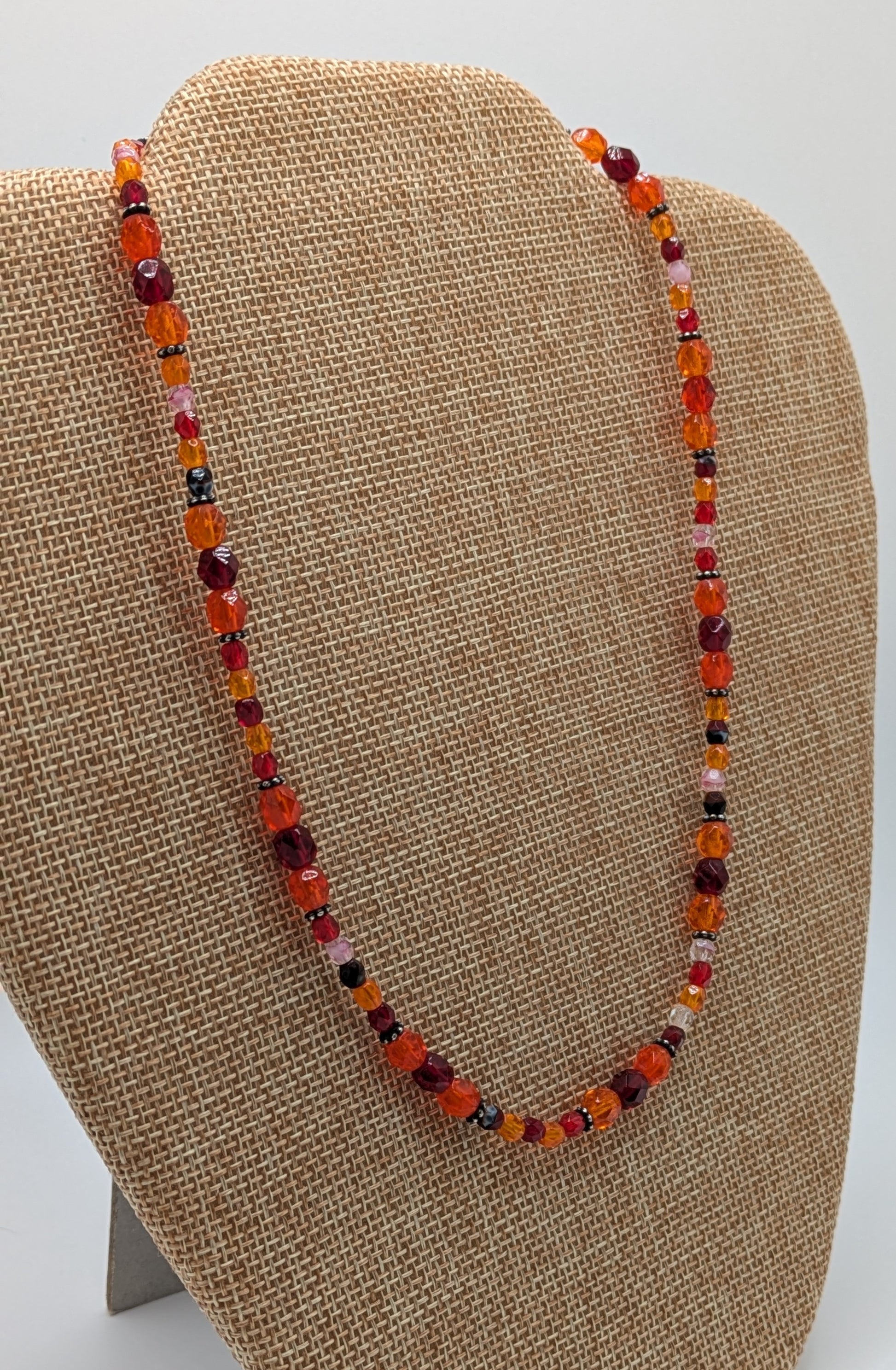 Beaded necklace on a brown display stand