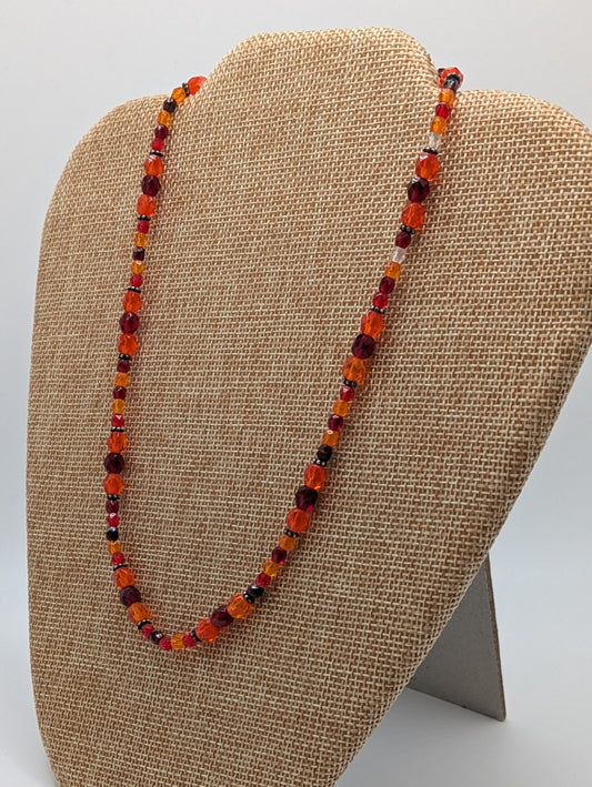 Beaded necklace on a beige display stand with a neutral background